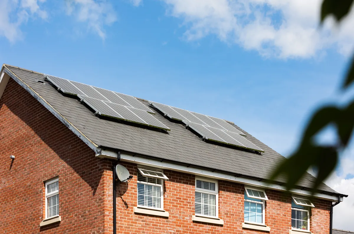 Ziegeldach mit Photovoltaikanlage vor blauem Himmel