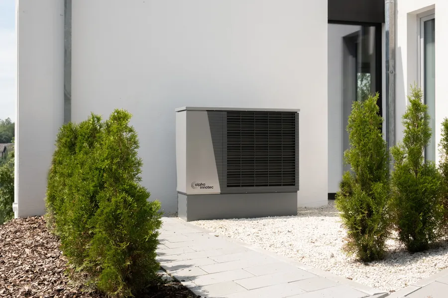 Wärmepumpe an der Außenwand eines modernen Hauses